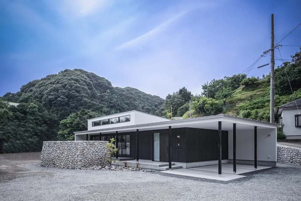 上芳養のコートハウス｜水平に伸びる庇と、焼杉板・石塀がつくる住まいの外観。